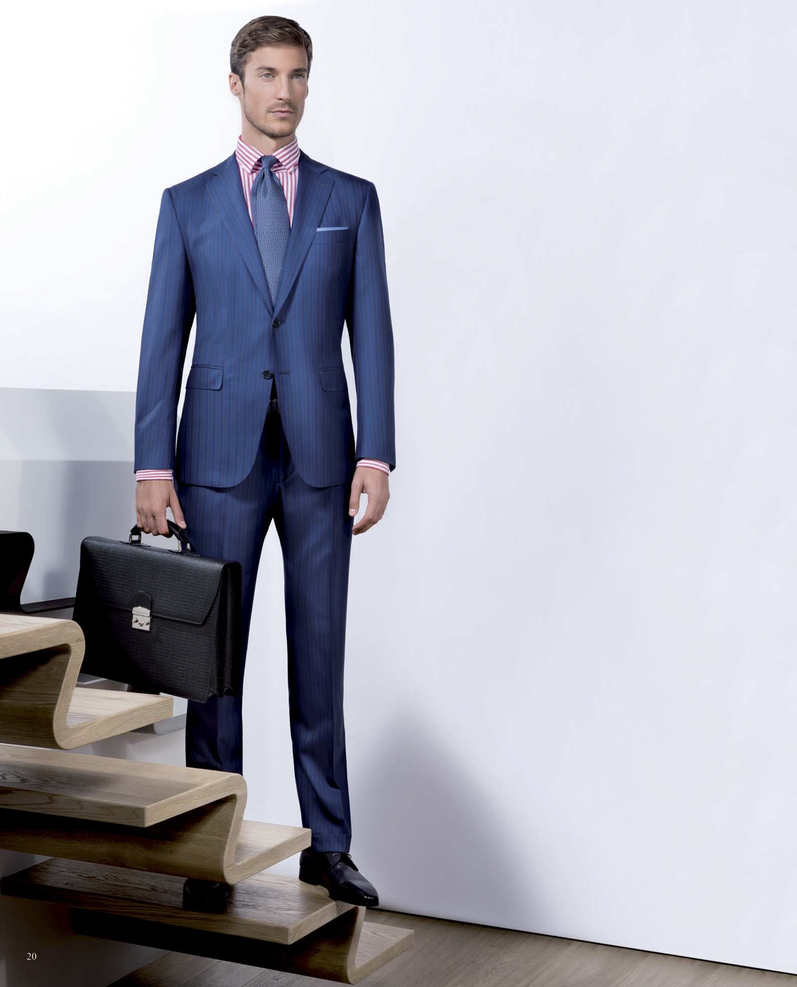Costume bleu marine droit, cravate, attaché-case à la main