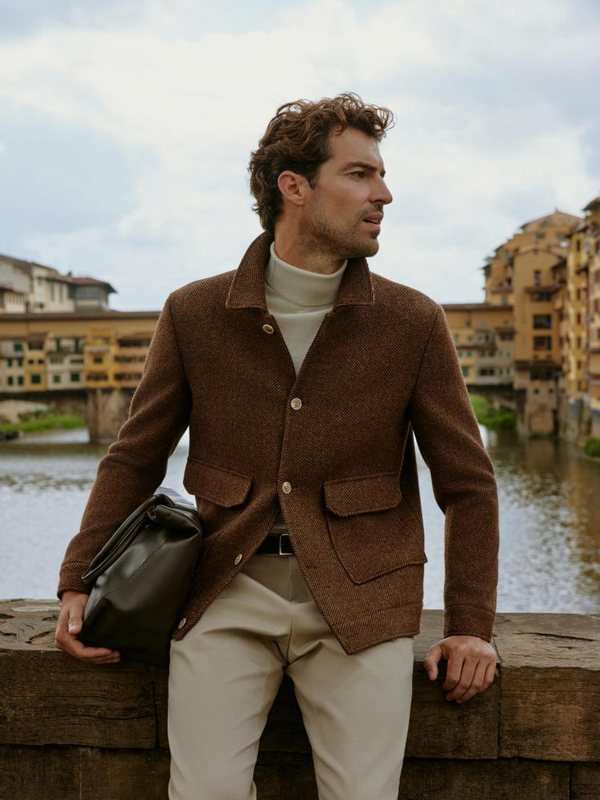 Blouson brun, col roulé et chino beige, au bord de l'Arno