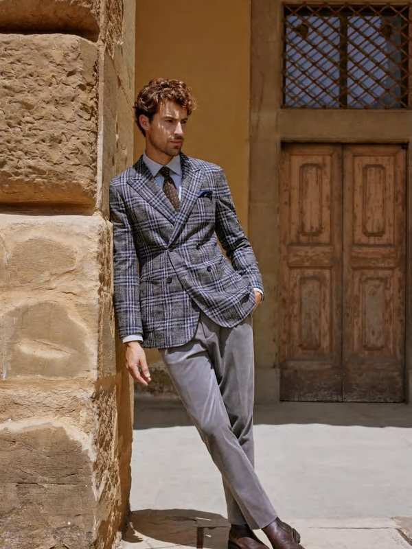 Veste croisée à carreaux bleus, pantalon gris et cravate, sous les arcades