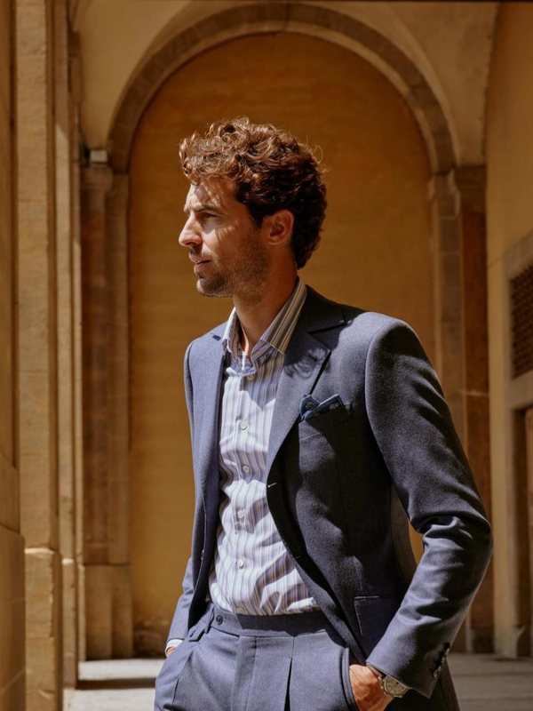 Veste bleu marine sur chemise rayée et pantalon gris