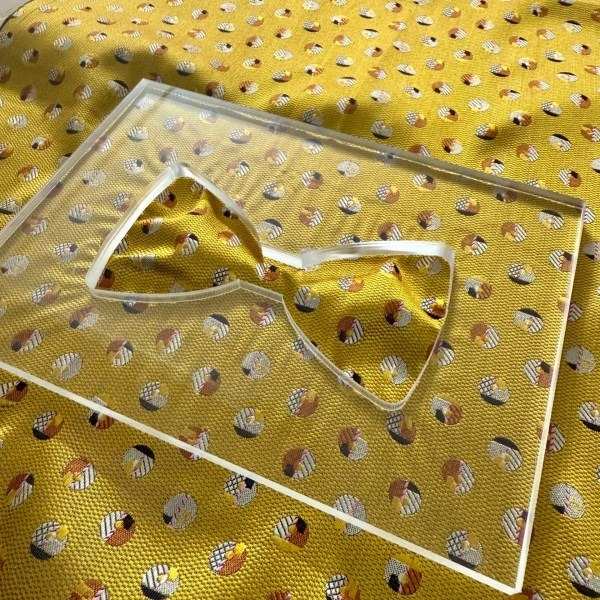 Soie jaune à motif géométrique sous le gabarit d'un nœud papillon