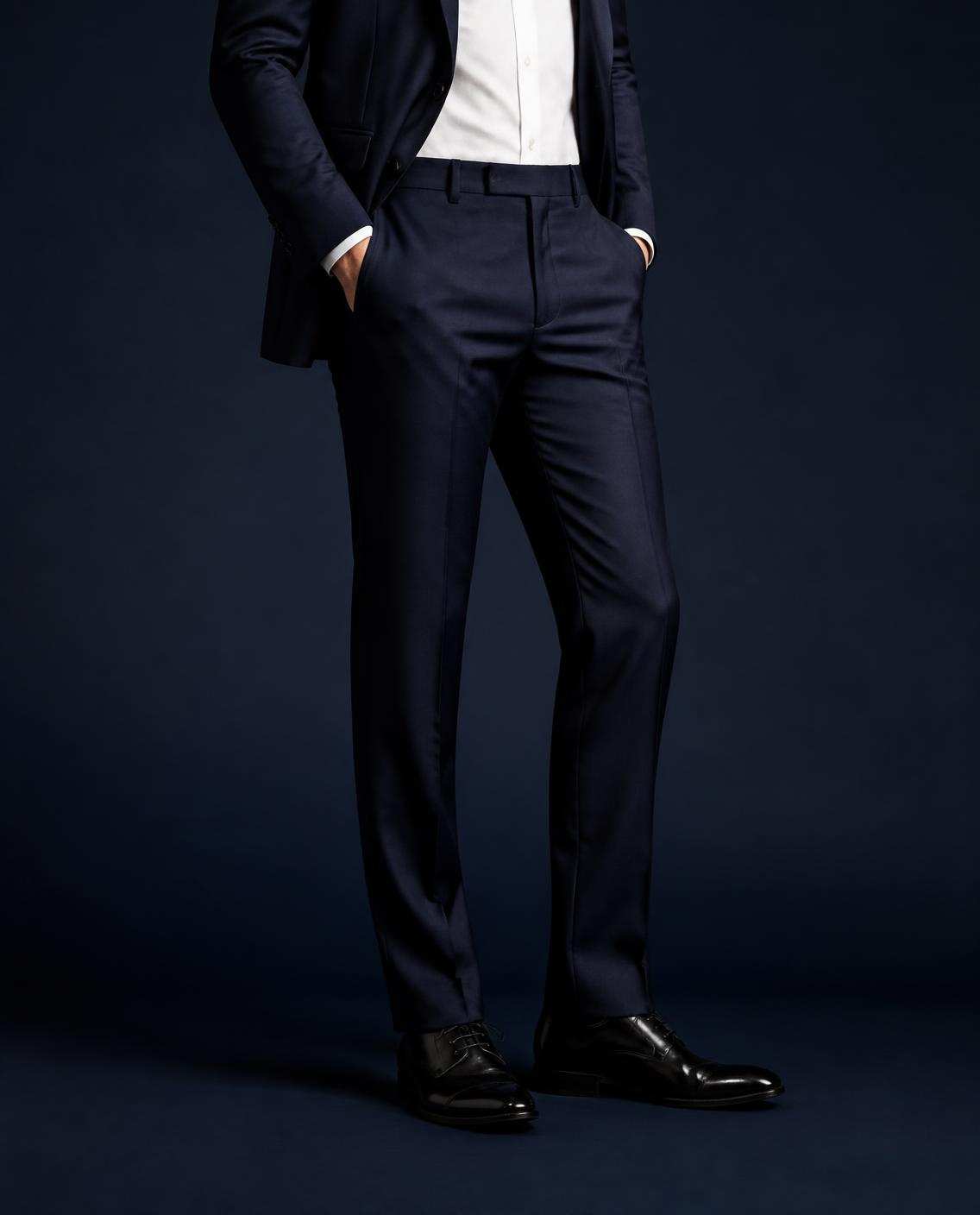 Pantalon de costume bleu marine, pli net, sur des richelieus noirs