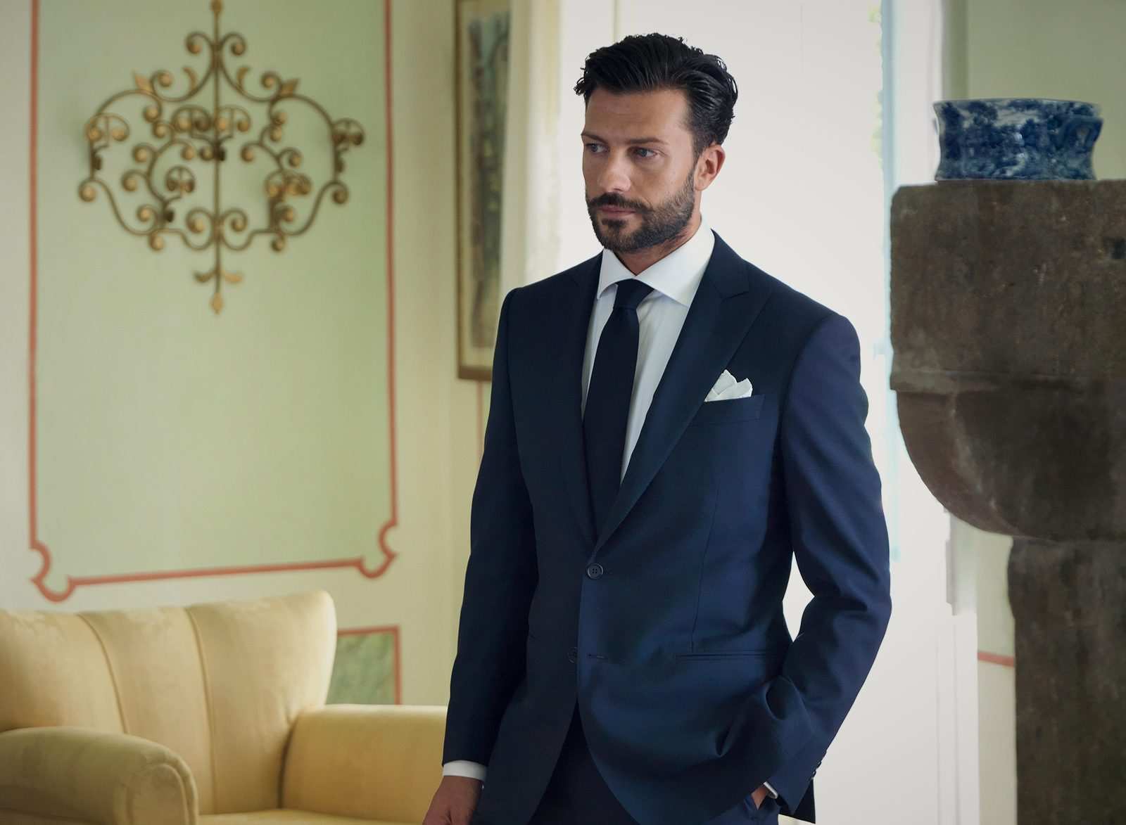 Homme en costume bleu nuit, chemise blanche, cravate marine et pochette blanche