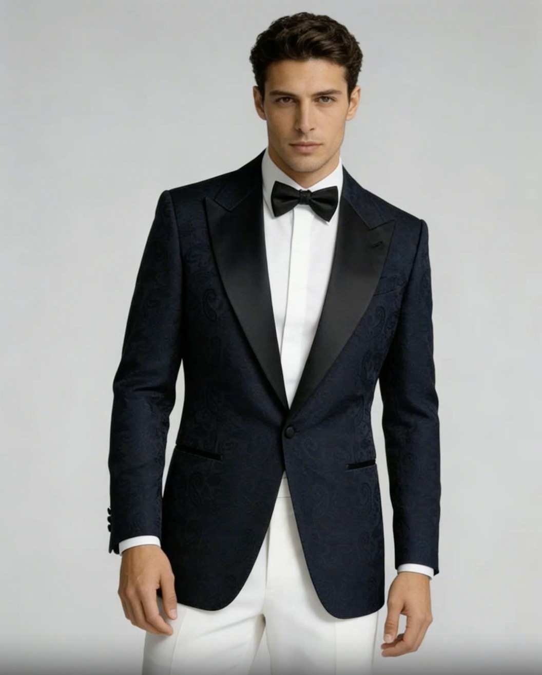 Veste de smoking bleu nuit à revers de satin, pantalon blanc, nœud papillon