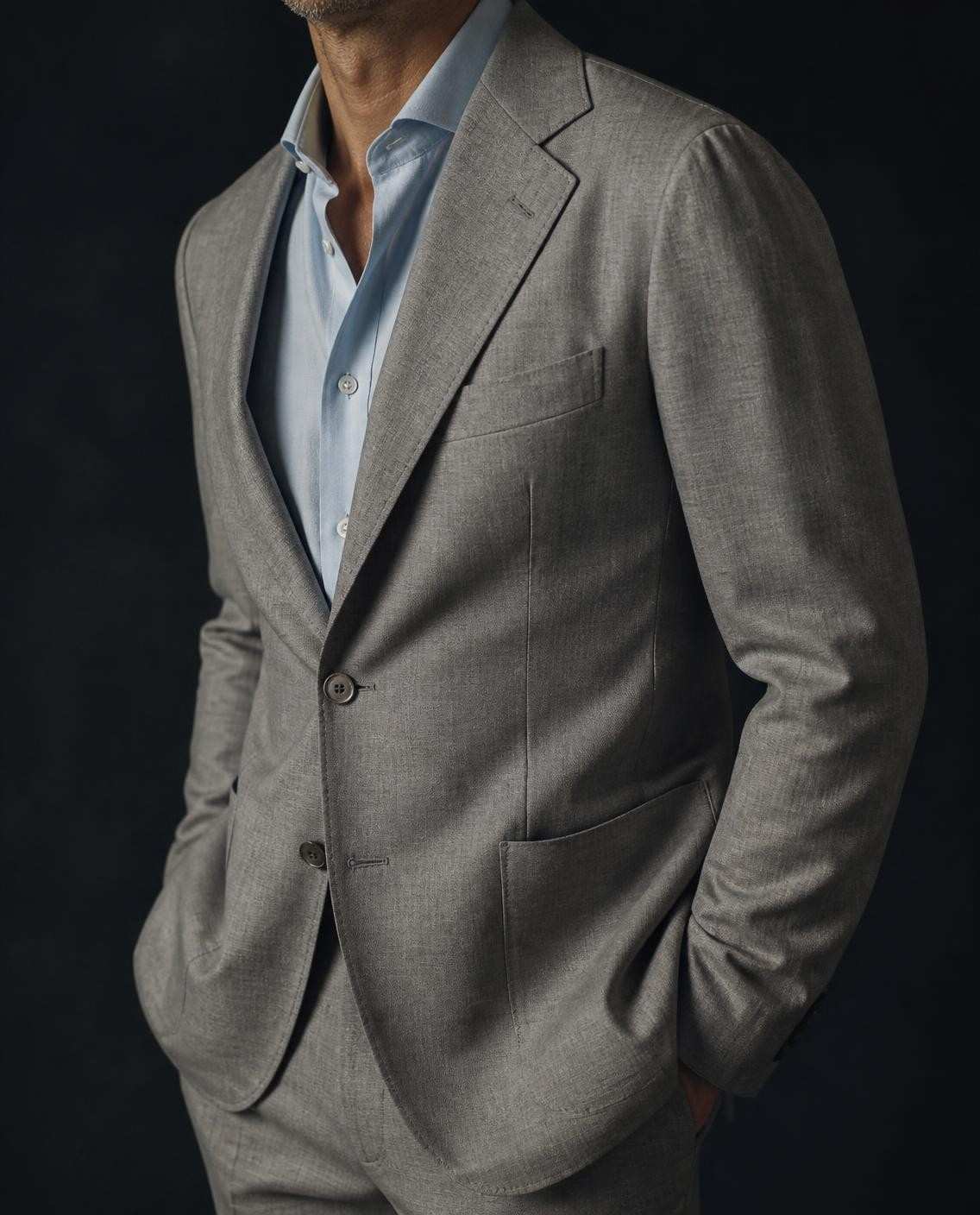 Coupe italienne : veste gris clair à épaule naturelle, montée comme une chemise, revers généreux et poches plaquées
