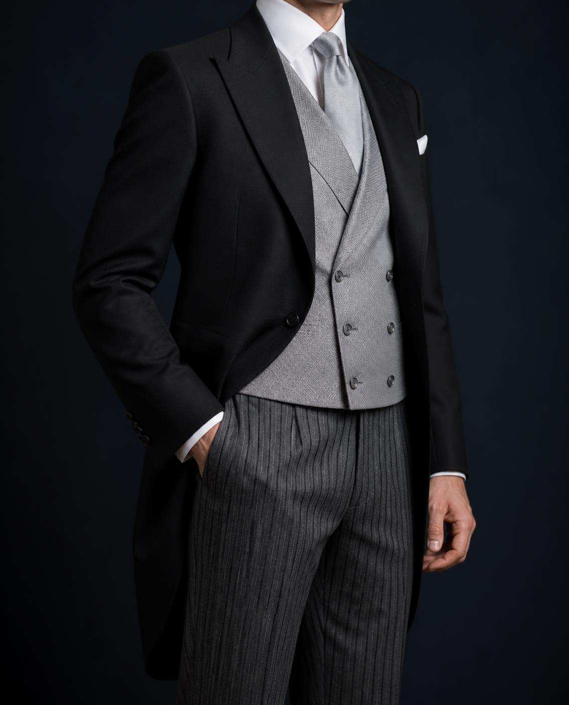 Tenue de jour : jaquette noire, gilet croisé gris perle, pantalon rayé et cravate argent