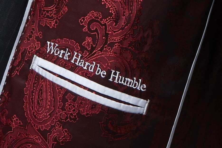 Inscription « Work Hard be Humble » brodée en fil blanc au-dessus de la poche intérieure, sur une doublure paisley bordeaux